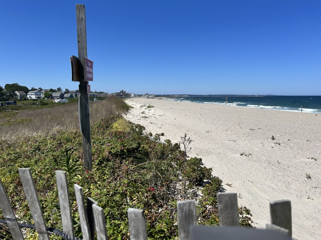 a beach with a fence and a sign (MyCoast AI)