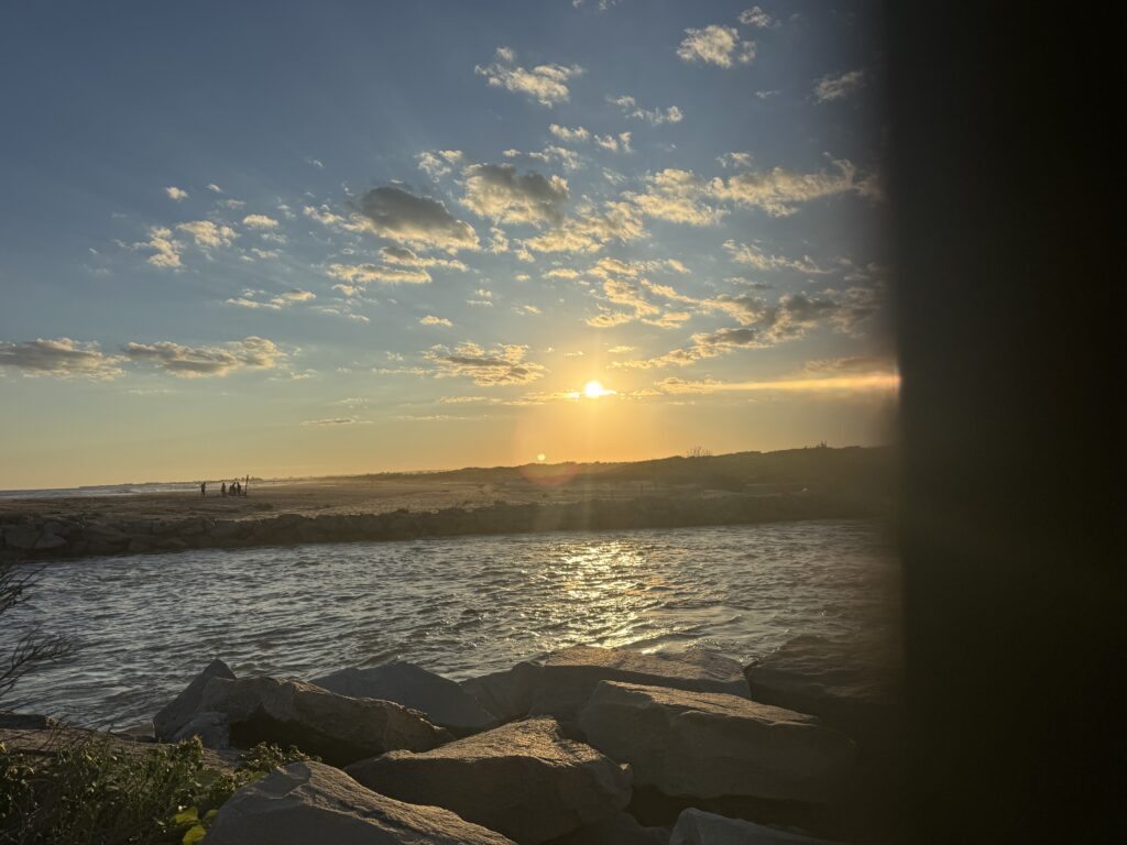 a body of water with rocks and a sunset in the background (MyCoast AI)