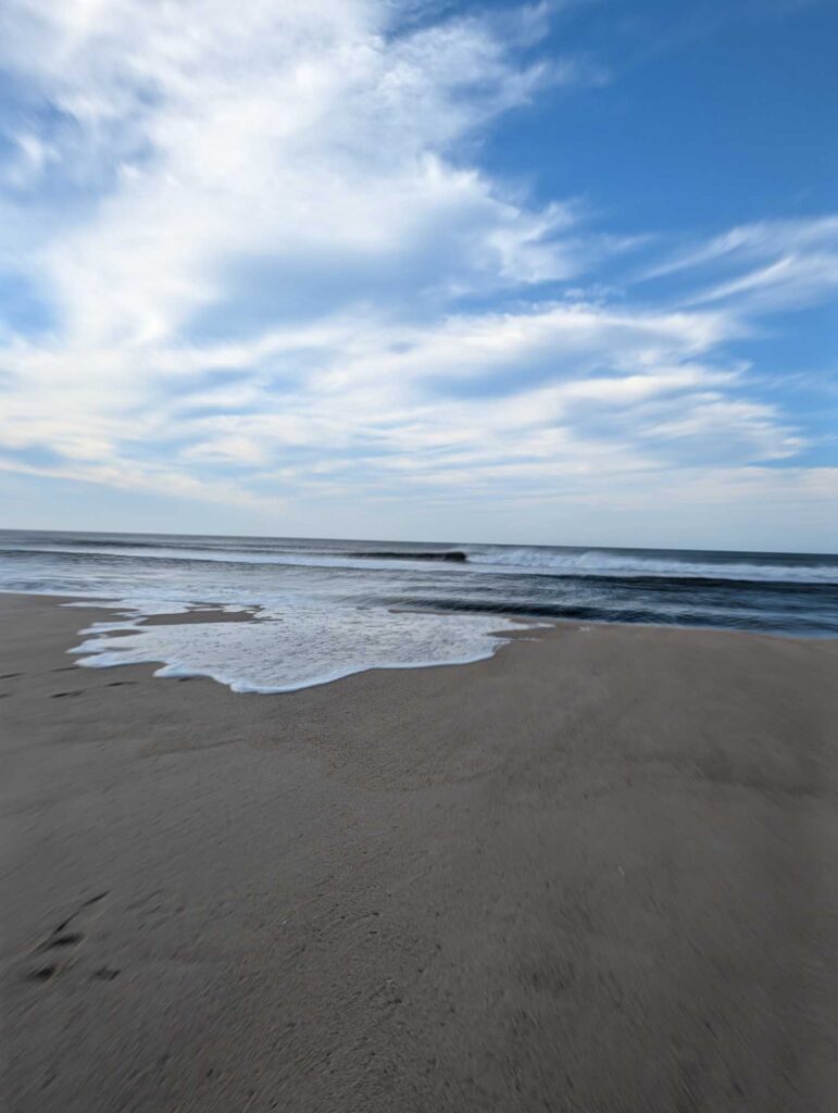 a sandy beach with waves crashing on it (MyCoast AI)