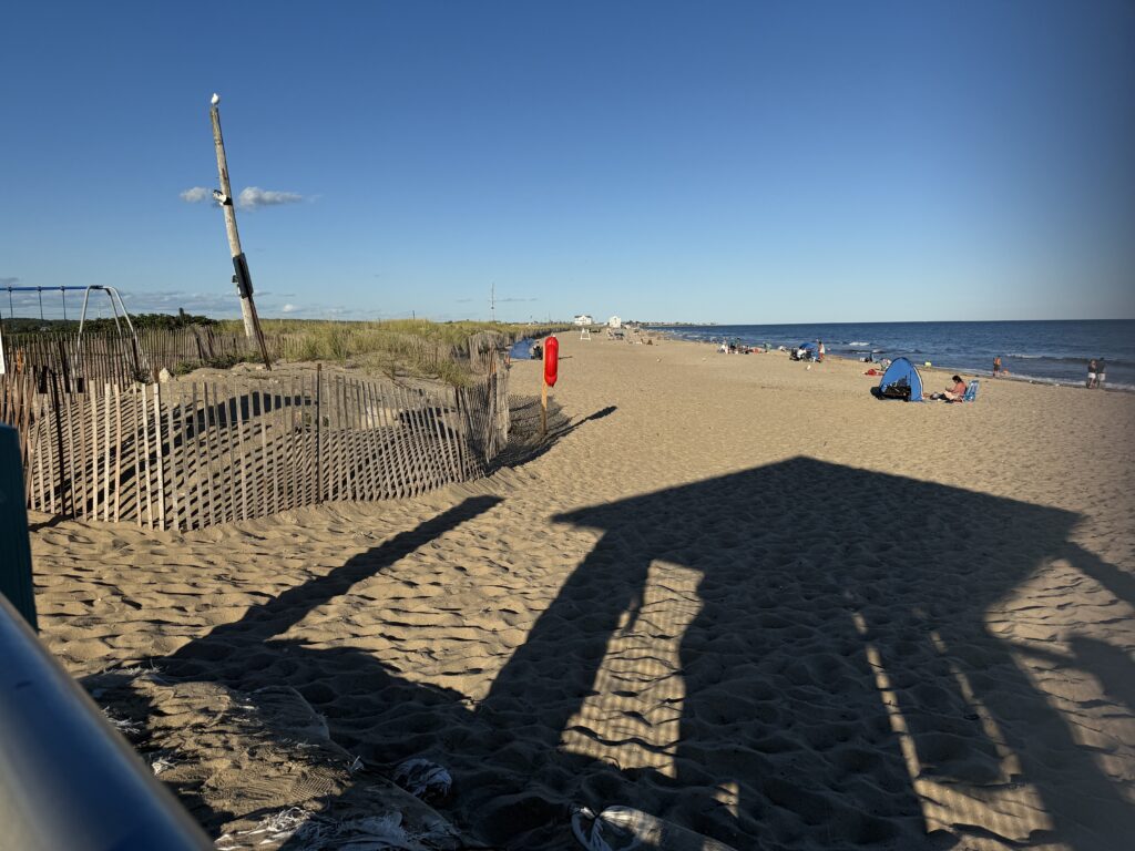 a sandy beach with a fence and a flag (MyCoast AI)
