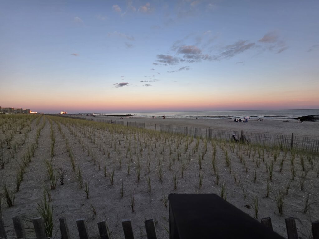 a beach with a fence and a body of water in the background (MyCoast AI)
