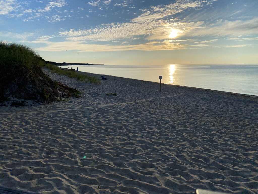 a sandy beach with a body of water and a sunset (MyCoast AI)