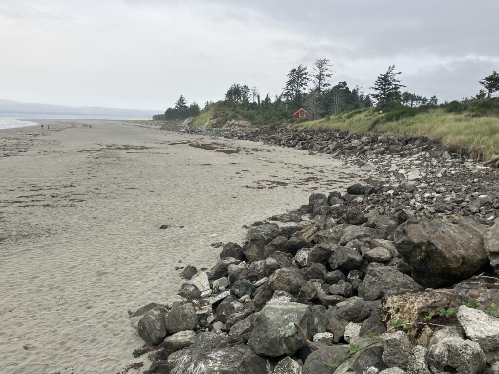 a rocky beach with a house in the distance (MyCoast AI)