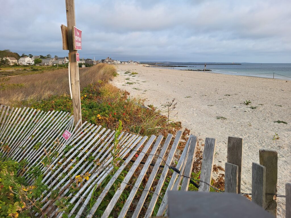 a beach with a fence and a sign (MyCoast AI)