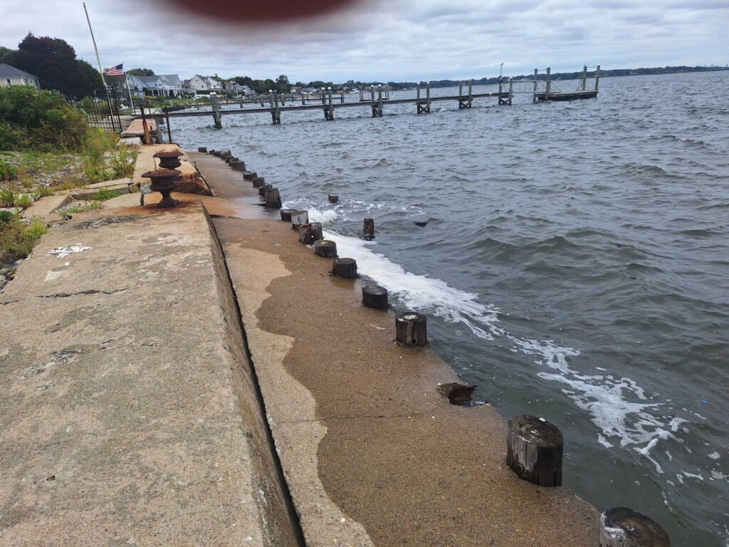 a concrete walkway next to a body of water (MyCoast AI)