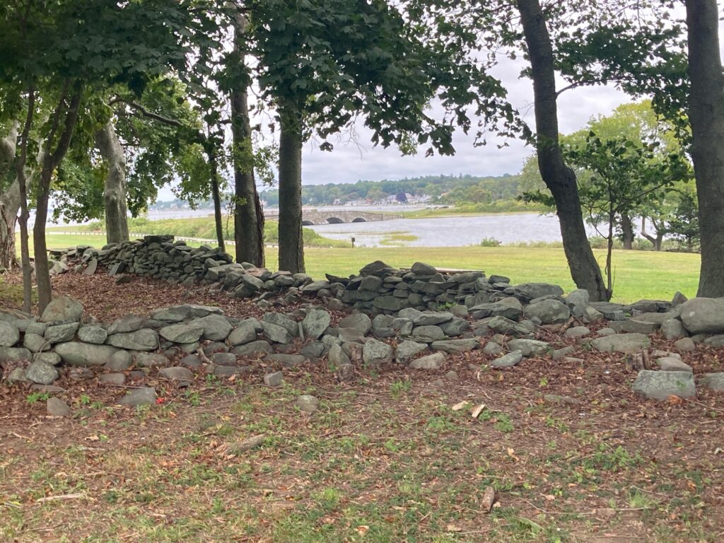 a stone wall with trees and grass (MyCoast AI)