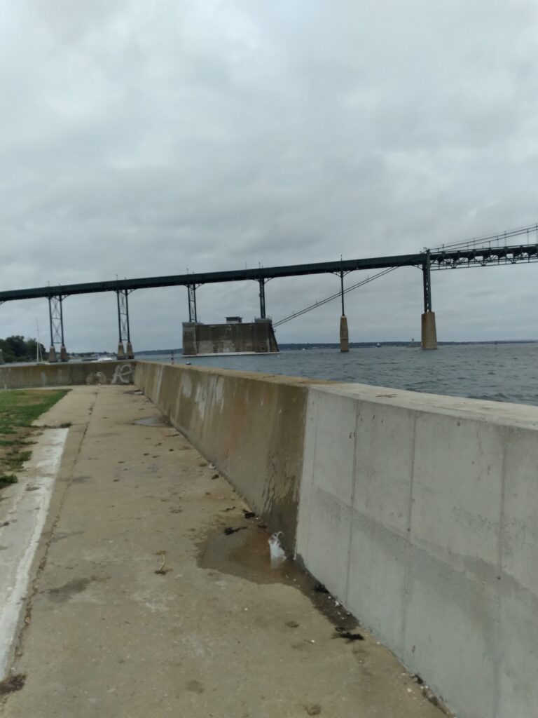 a concrete wall with a bridge in the background (MyCoast AI)