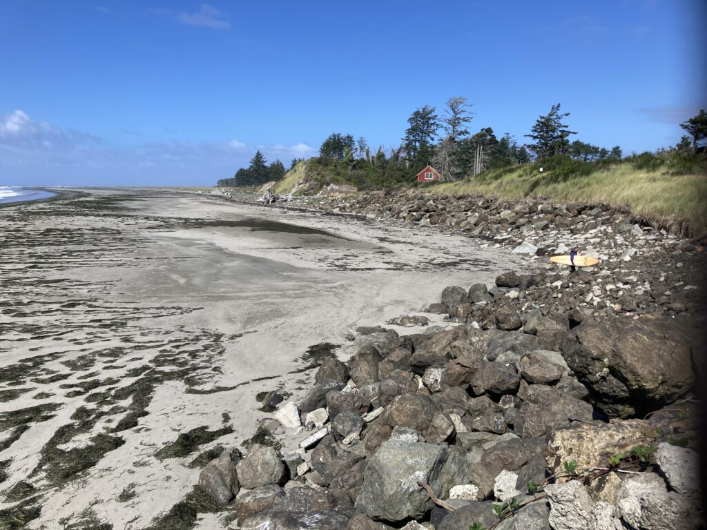 a rocky beach with a house in the background (MyCoast AI)