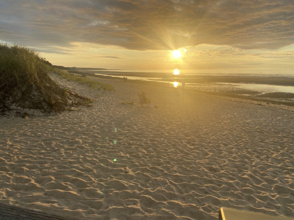 a sandy beach with the sun setting (MyCoast AI)