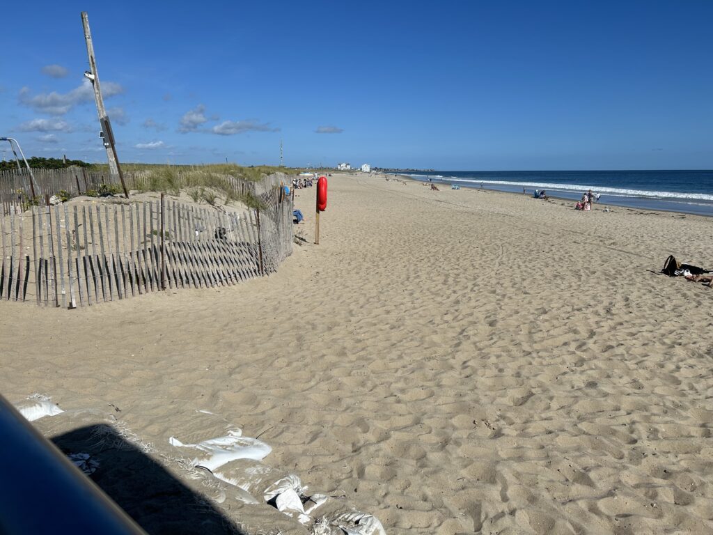 a sandy beach with a fence and a wood fence (MyCoast AI)