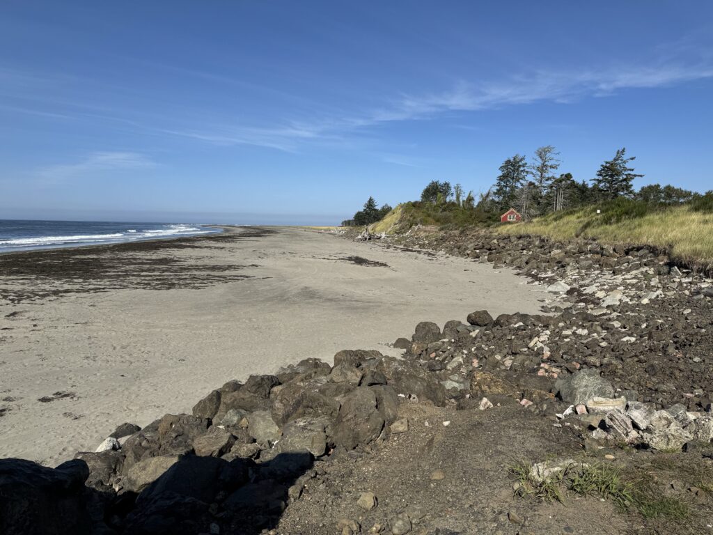 a rocky beach with trees and a red tent (MyCoast AI)