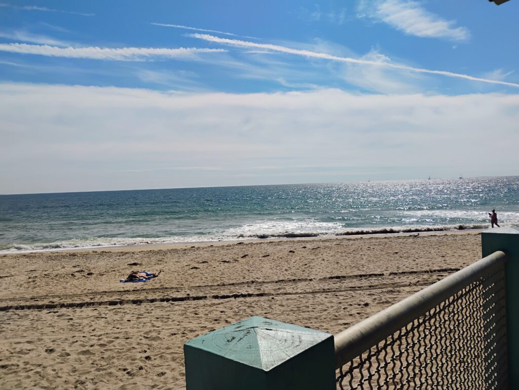 a beach with a blue umbrella (MyCoast AI)