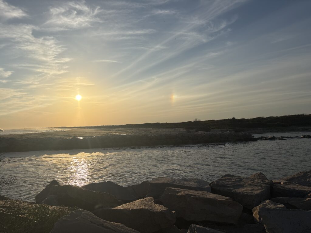 a body of water with rocks and a sunset (MyCoast AI)