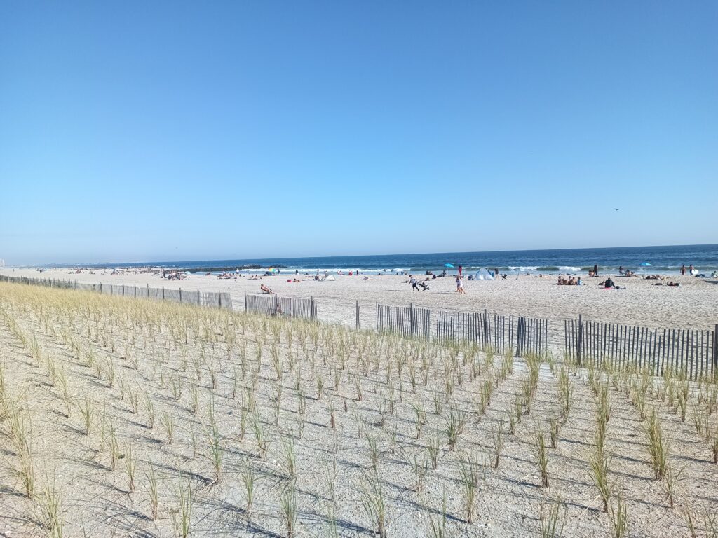 a beach with a fence and people (MyCoast AI)