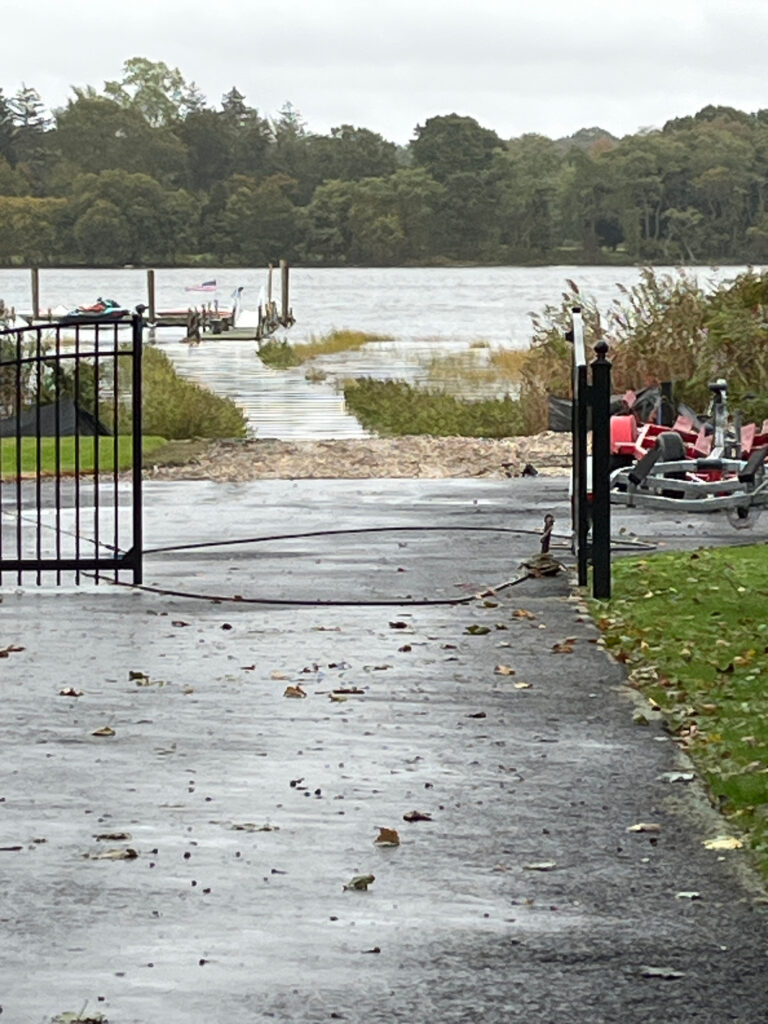 a flooded area with a fence and a metal gate (MyCoast AI)
