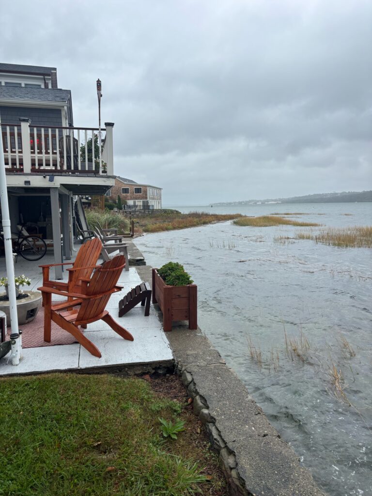 a chair and a table on a dock by a body of water (MyCoast AI)