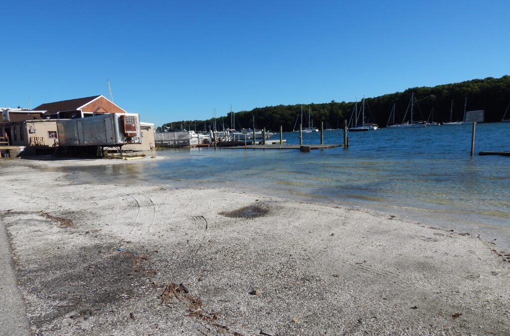 a beach with a dock and a building on the shore (MyCoast AI)