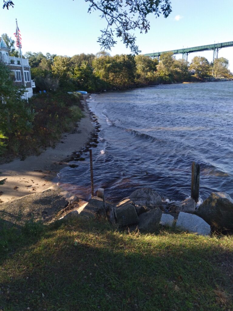 a body of water with rocks and a bridge in the background (MyCoast AI)