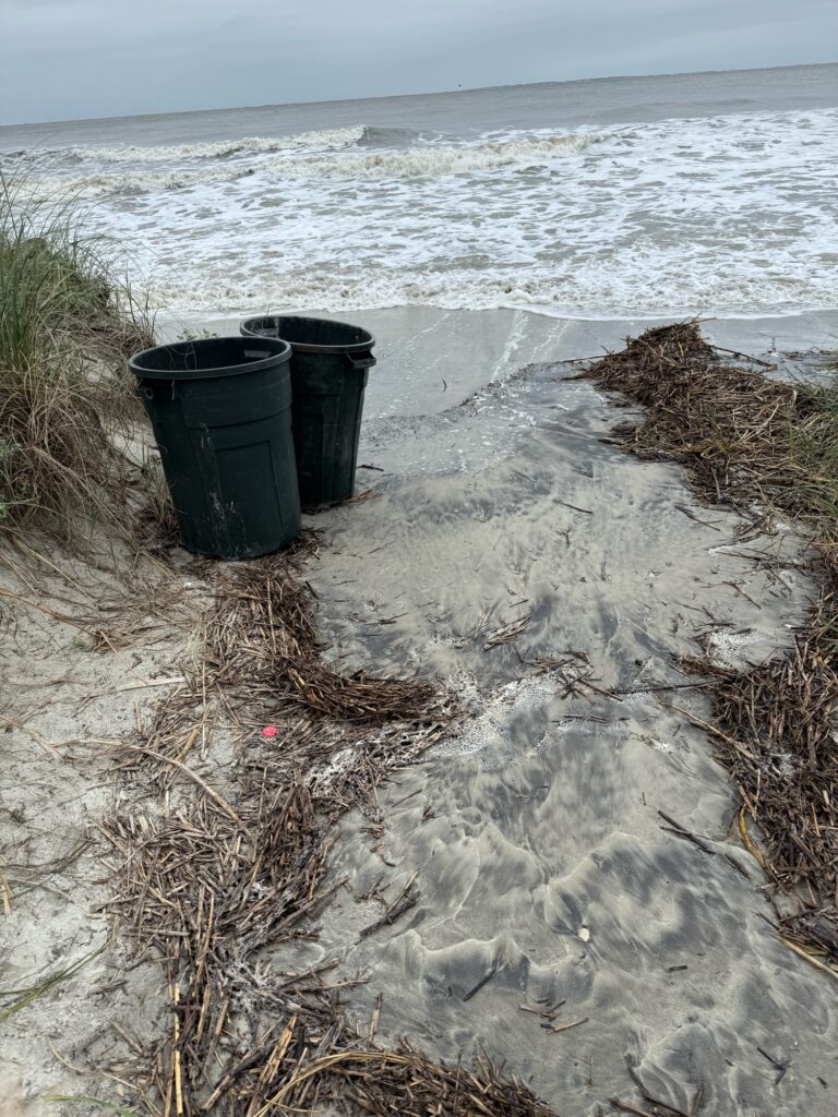 a couple of black buckets on a beach (MyCoast AI)