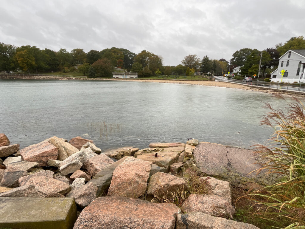 a body of water with rocks and a dock in the distance (MyCoast AI)
