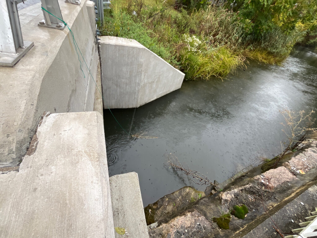 a small pond with a concrete wall (MyCoast AI)