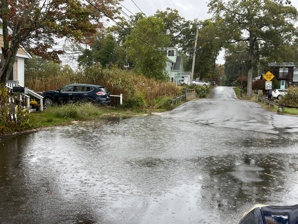 a flooded street with a car parked on the side (MyCoast AI)