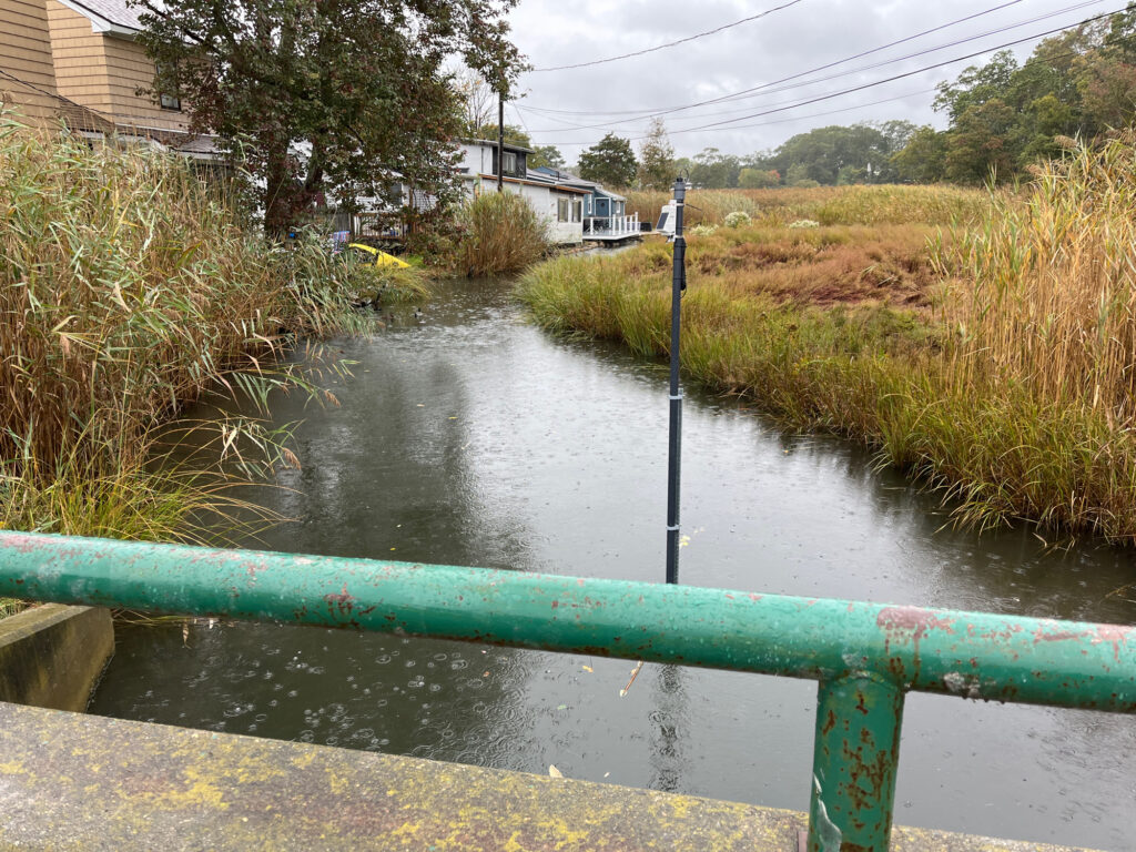 a flooded street with a green railing (MyCoast AI)
