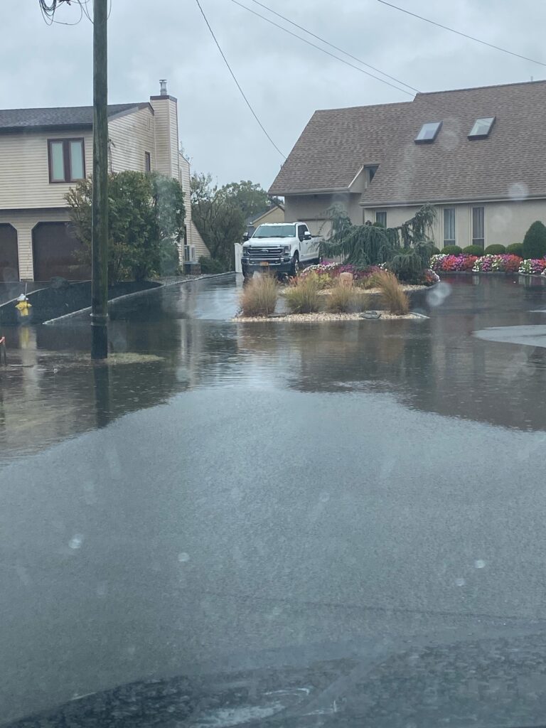 a flooded street with houses and a truck parked on the side (MyCoast AI)