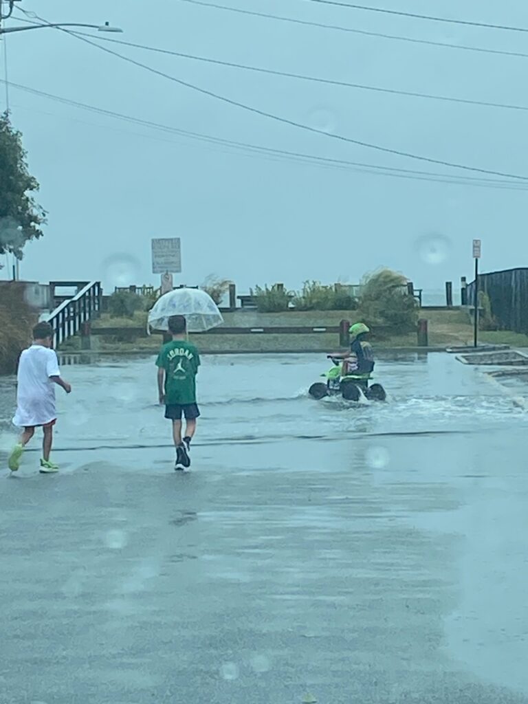 a group of people walking in the rain with umbrellas (MyCoast AI)