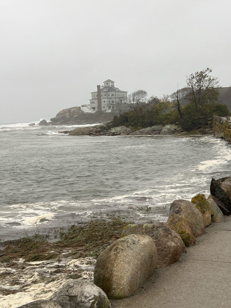 a rocky beach with a building on the shore (MyCoast AI)