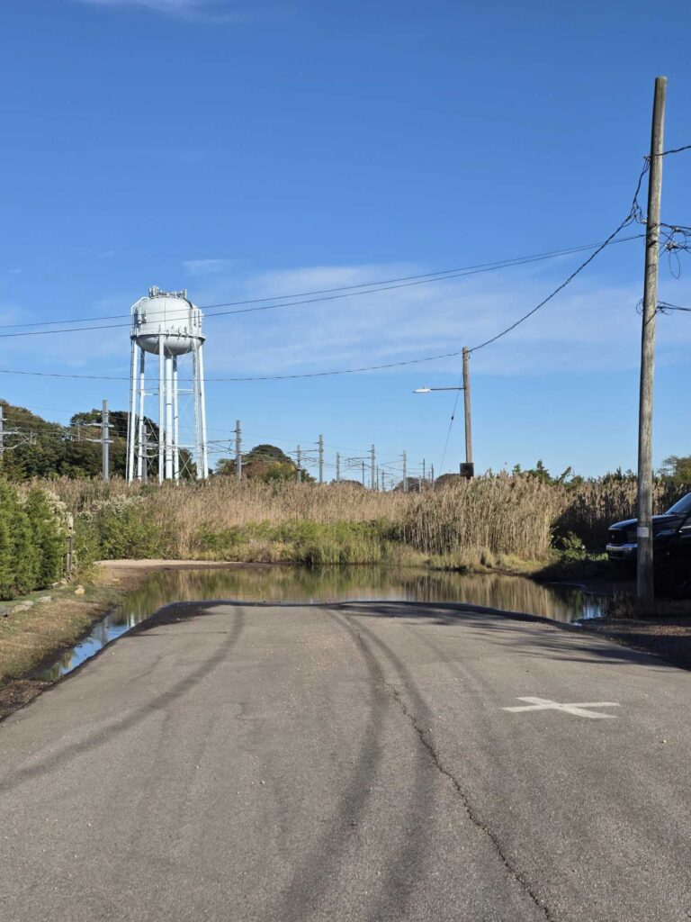 a road with power lines and a water tower on the side (MyCoast AI)