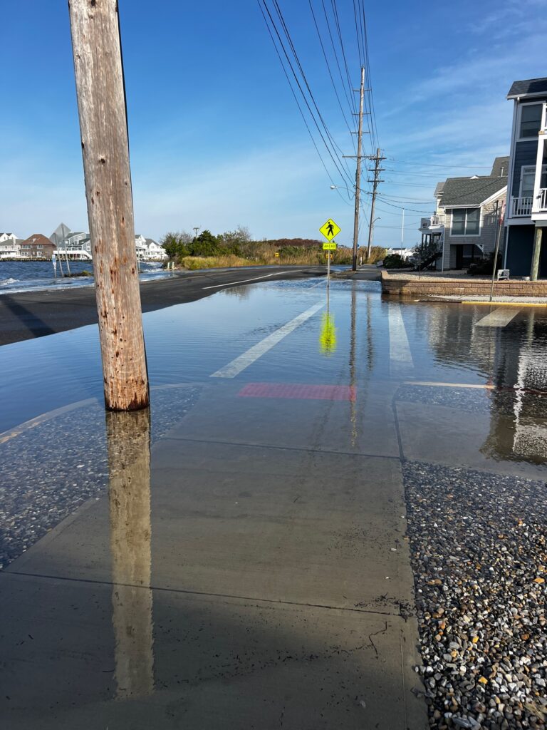 a flooded street with a yellow sign (MyCoast AI)