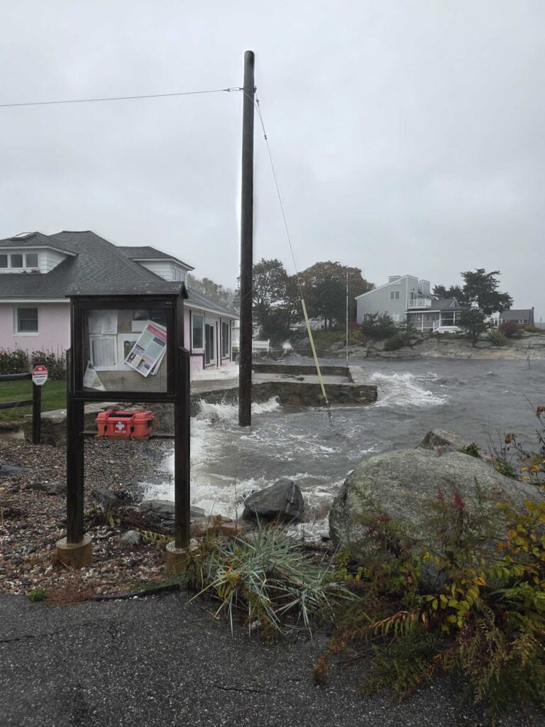 a flooded street with a house and a telephone pole (MyCoast AI)