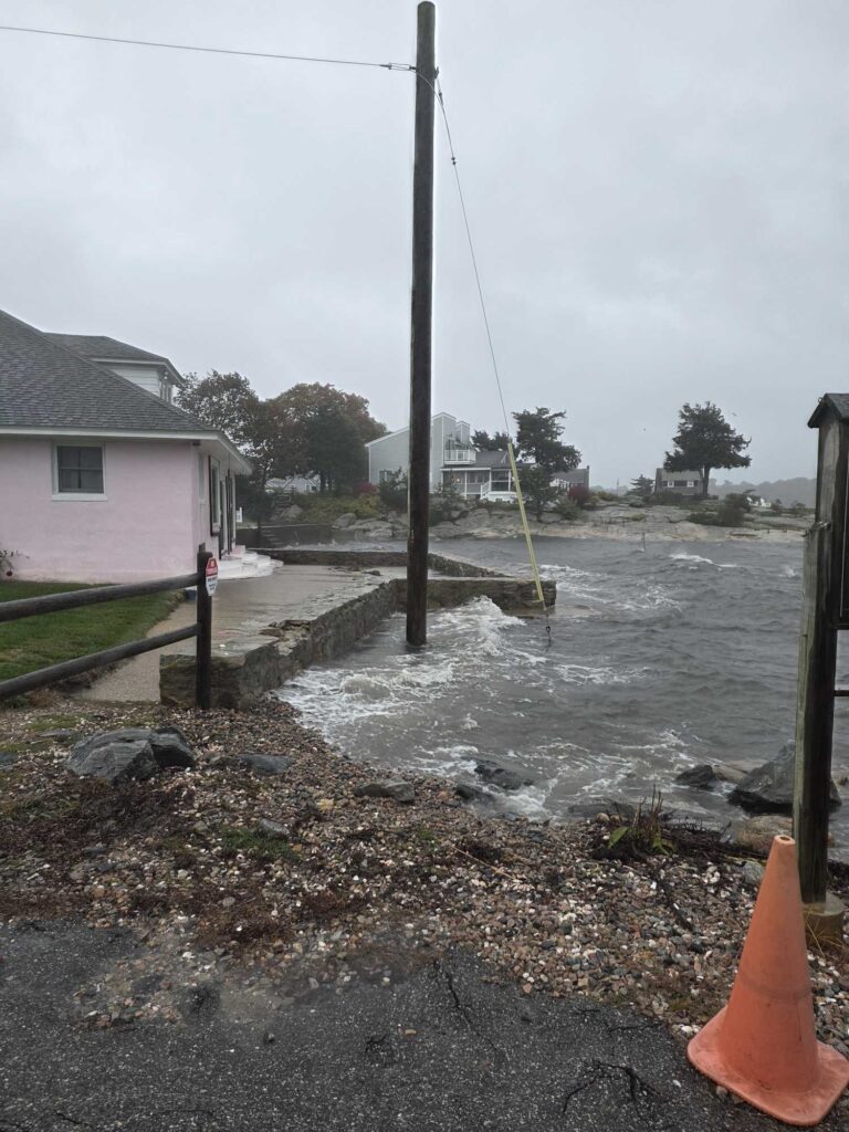 a flooded street with a pole and a house (MyCoast AI)