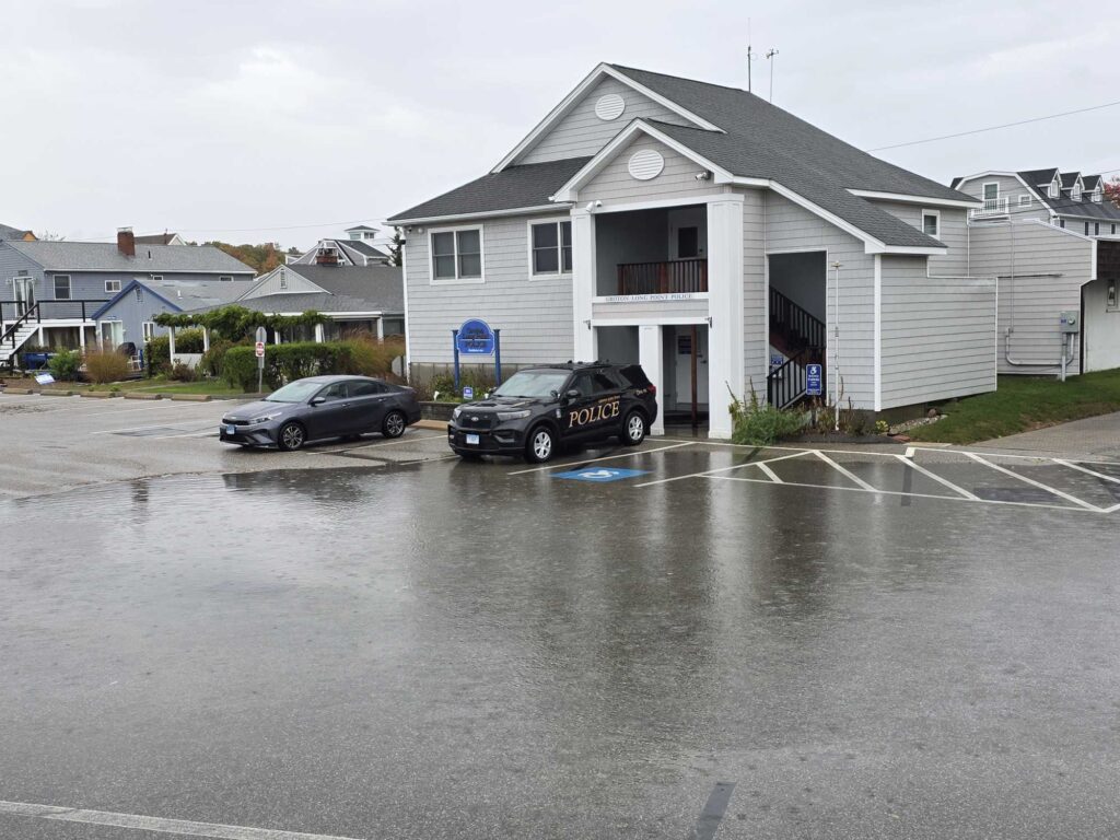 a couple of cars parked in a parking lot next to a house (MyCoast AI)