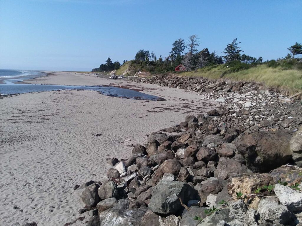 a rocky beach with a house in the distance (MyCoast AI)