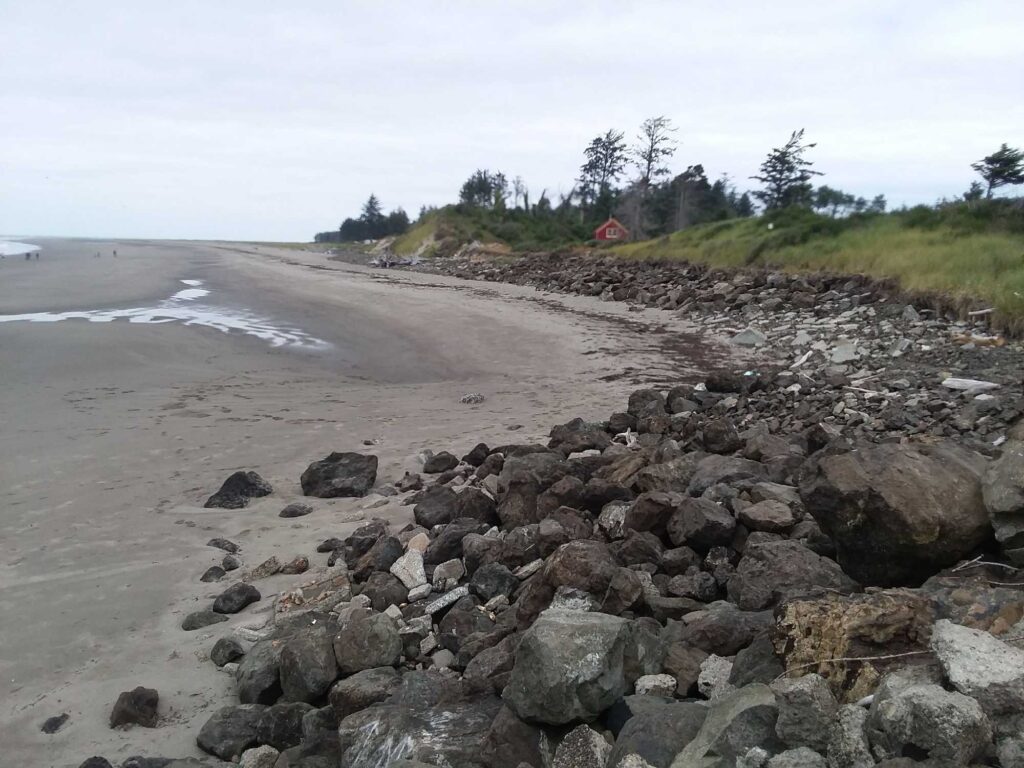 a rocky beach with a red house (MyCoast AI)