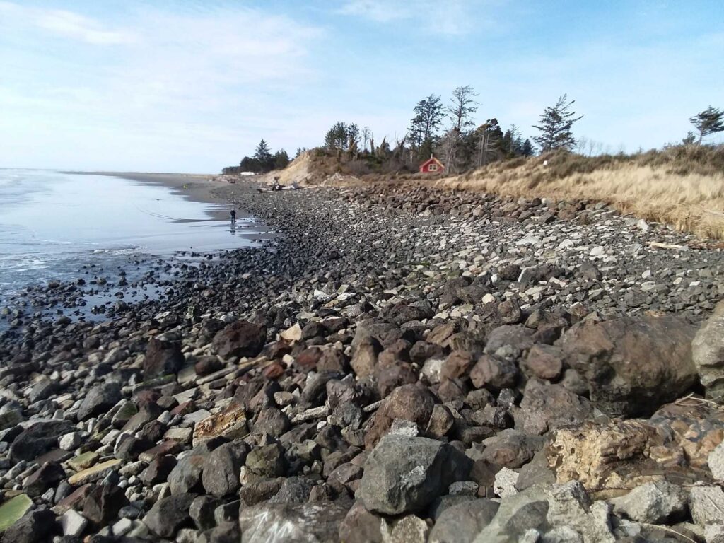 a rocky beach with a house in the distance (MyCoast AI)