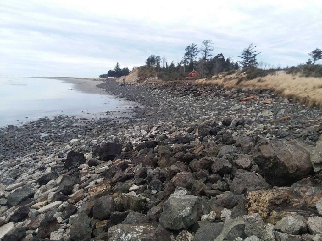 a rocky beach with a house in the distance (MyCoast AI)