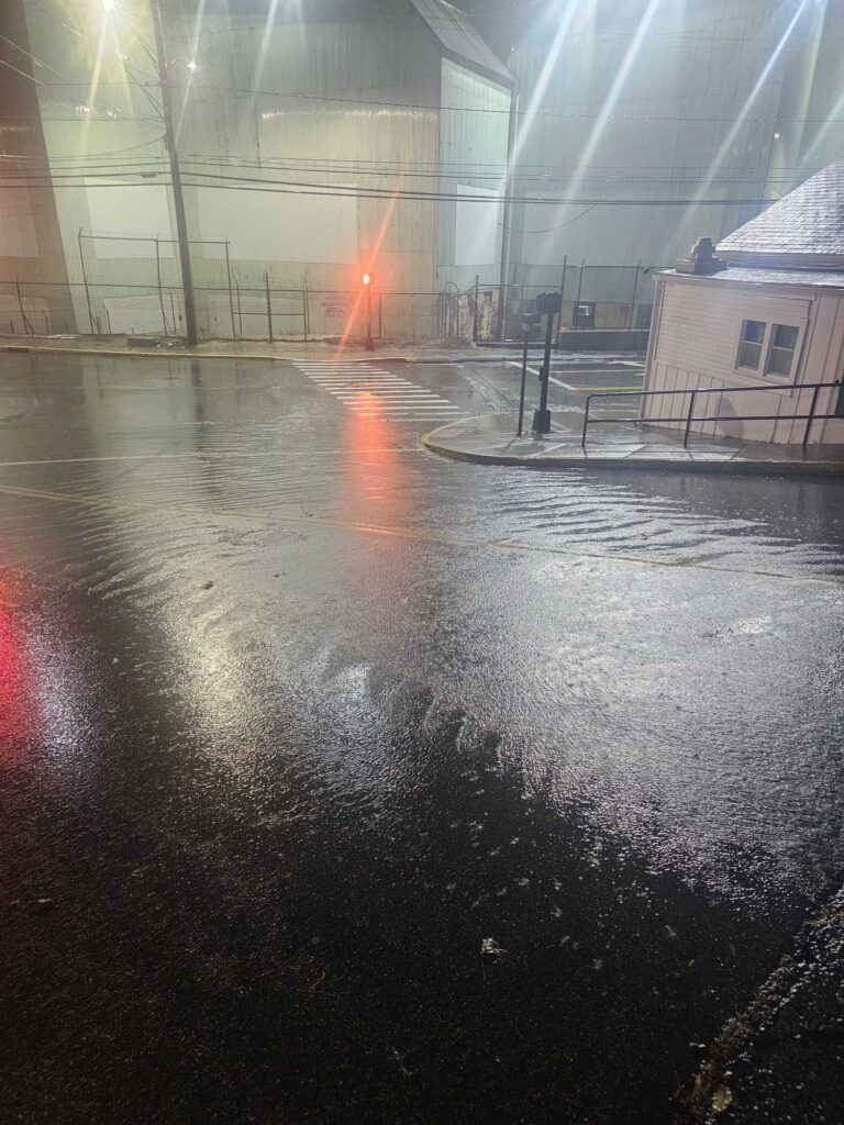 a wet courtyard with buildings and a fence (MyCoast AI)