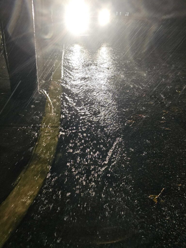 a wet sidewalk with a light shining on it (MyCoast AI)