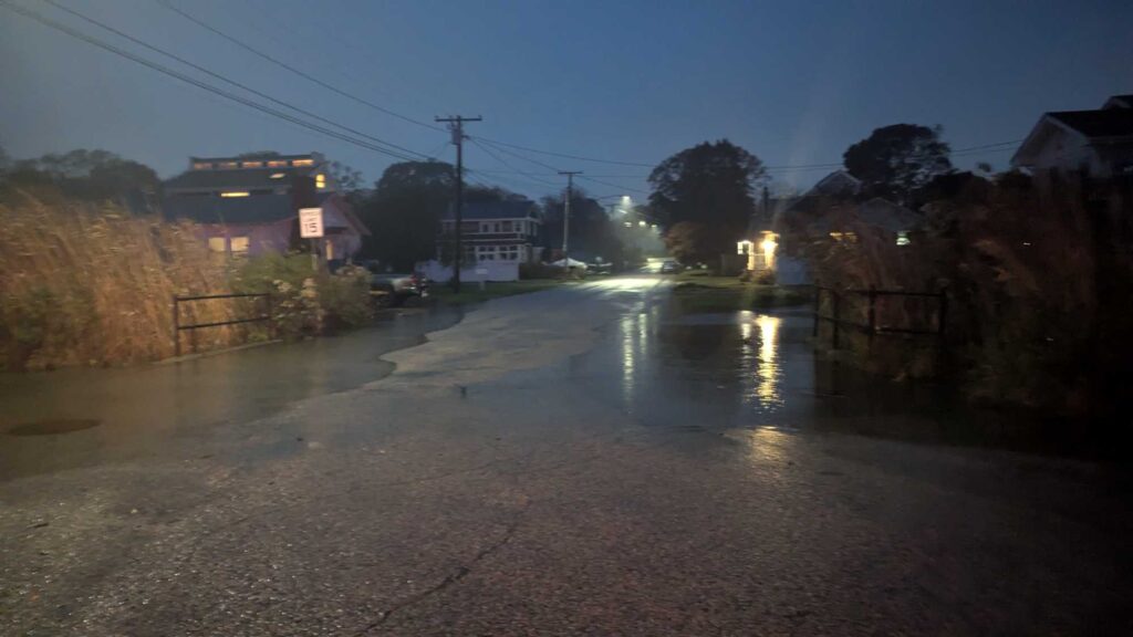 a wet road with houses on either side of it (MyCoast AI)