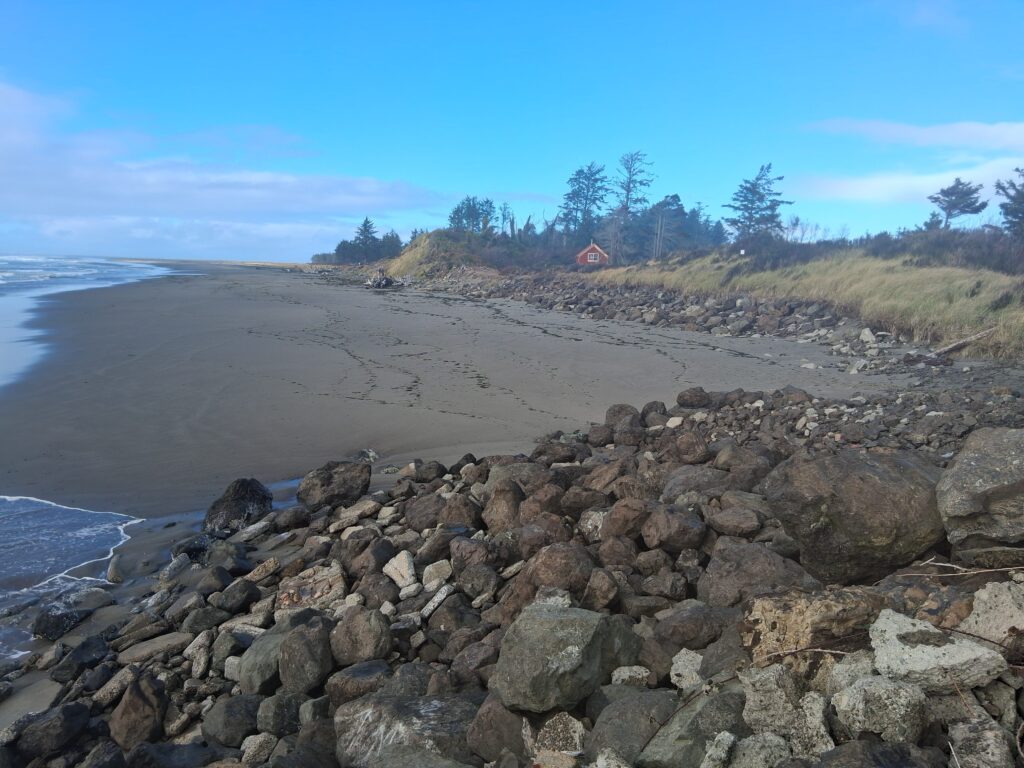 a rocky beach with a house in the distance (MyCoast AI)