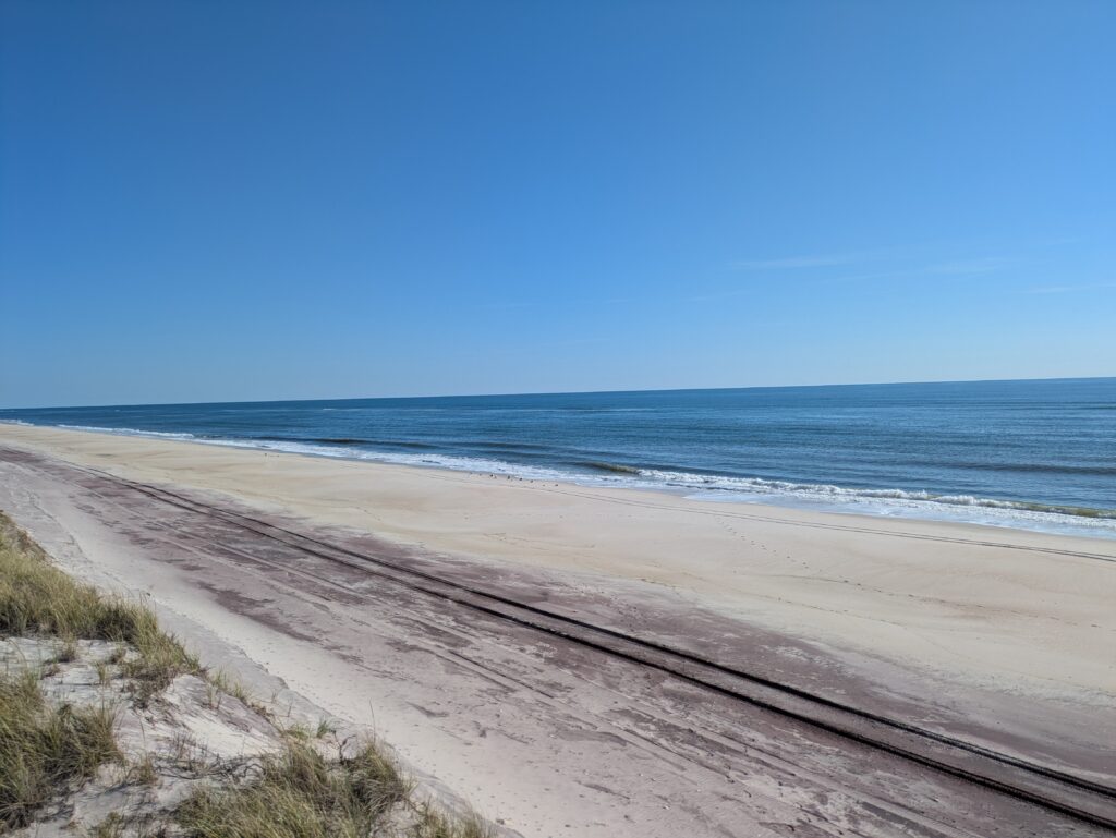 a sandy beach with water and blue sky (MyCoast AI)