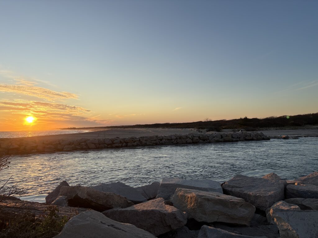 a body of water with rocks and a sunset in the background (MyCoast AI)