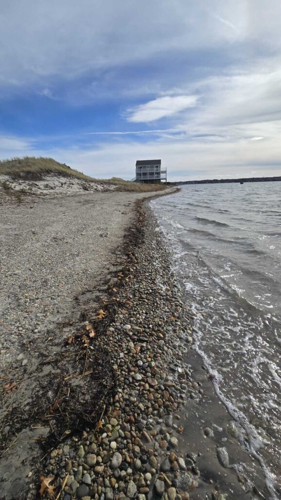 a rocky beach with a building on the shore (MyCoast AI)