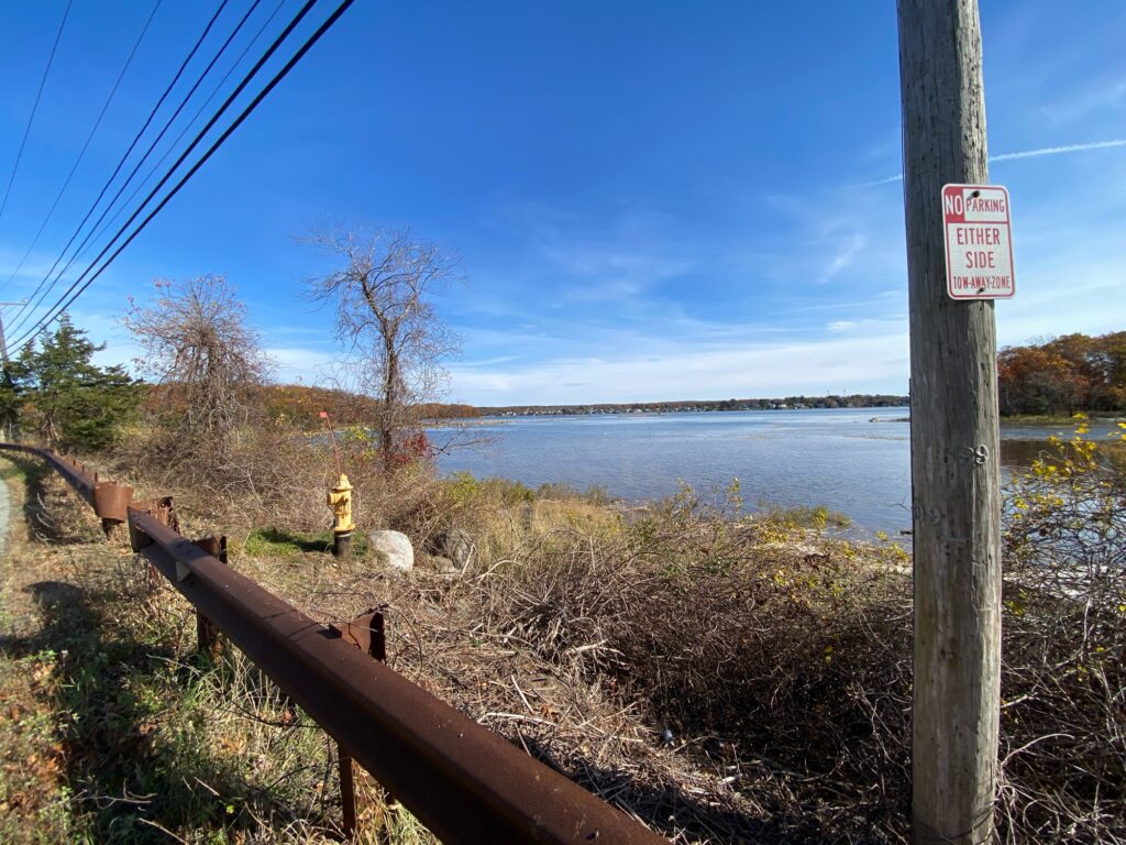a sign on a post next to a body of water (MyCoast AI)