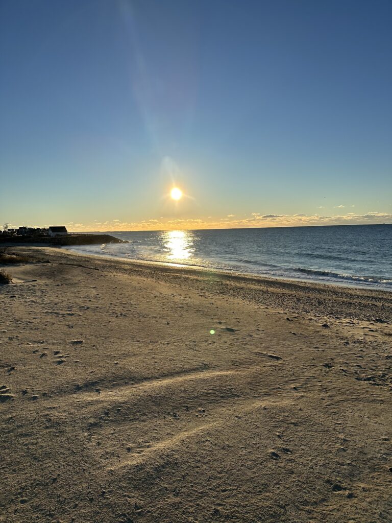 a beach with the sun setting (MyCoast AI)
