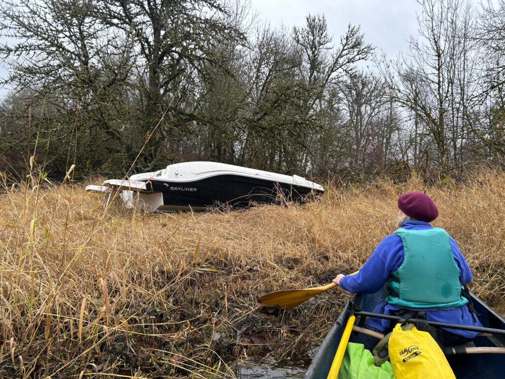 a person in a kayak in a field with a crashed boat (MyCoast AI)