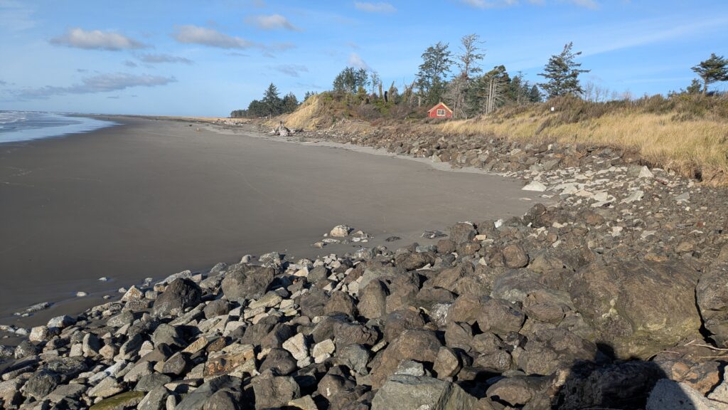 a rocky beach with a red house (MyCoast AI)